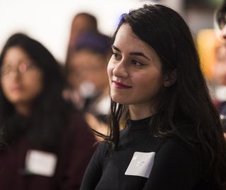 Close up on smiling young woman in audience.