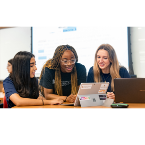 Three woman working around a computer