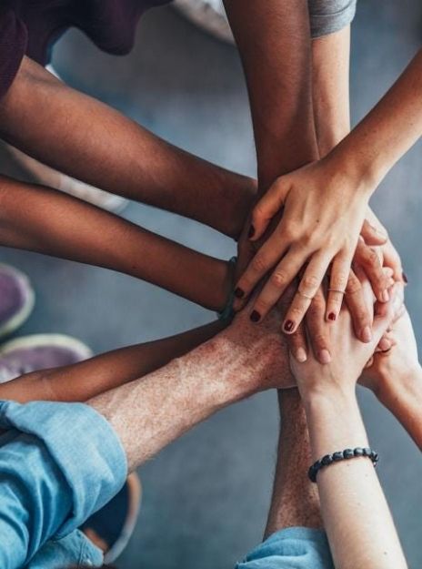 a team with their hands together in the center of a circle