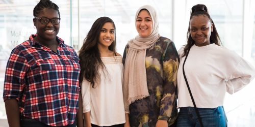 Four women smile at the camera